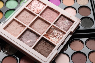 Photo of Different used eyeshadow palettes as background, closeup