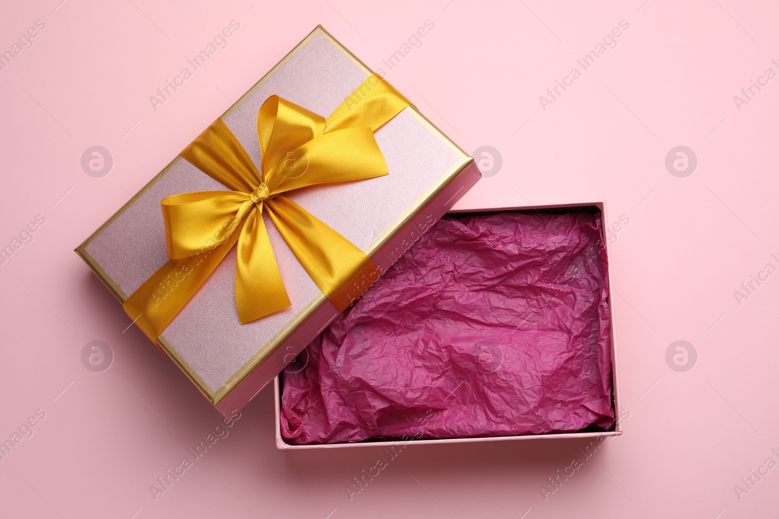 Photo of Open gift box with beautiful lid on pink background, top view