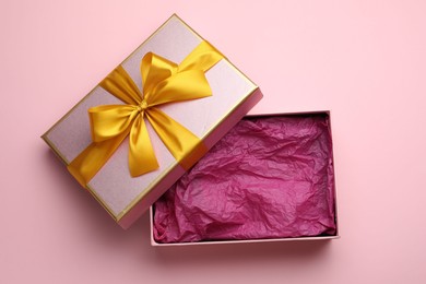 Photo of Open gift box with beautiful lid on pink background, top view
