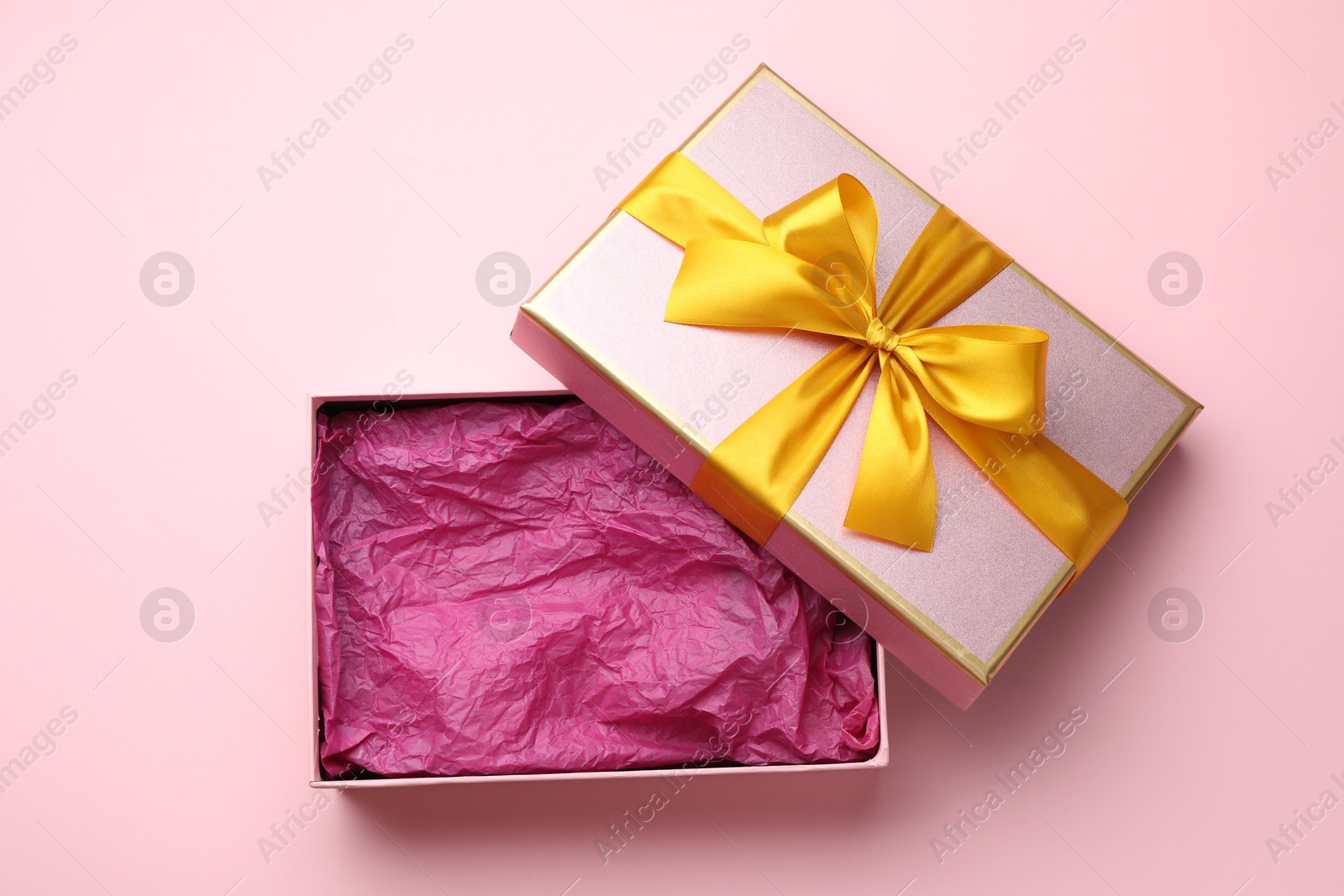Photo of Open gift box with beautiful lid on pink background, top view