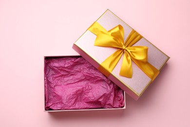 Photo of Open gift box with beautiful lid on pink background, top view