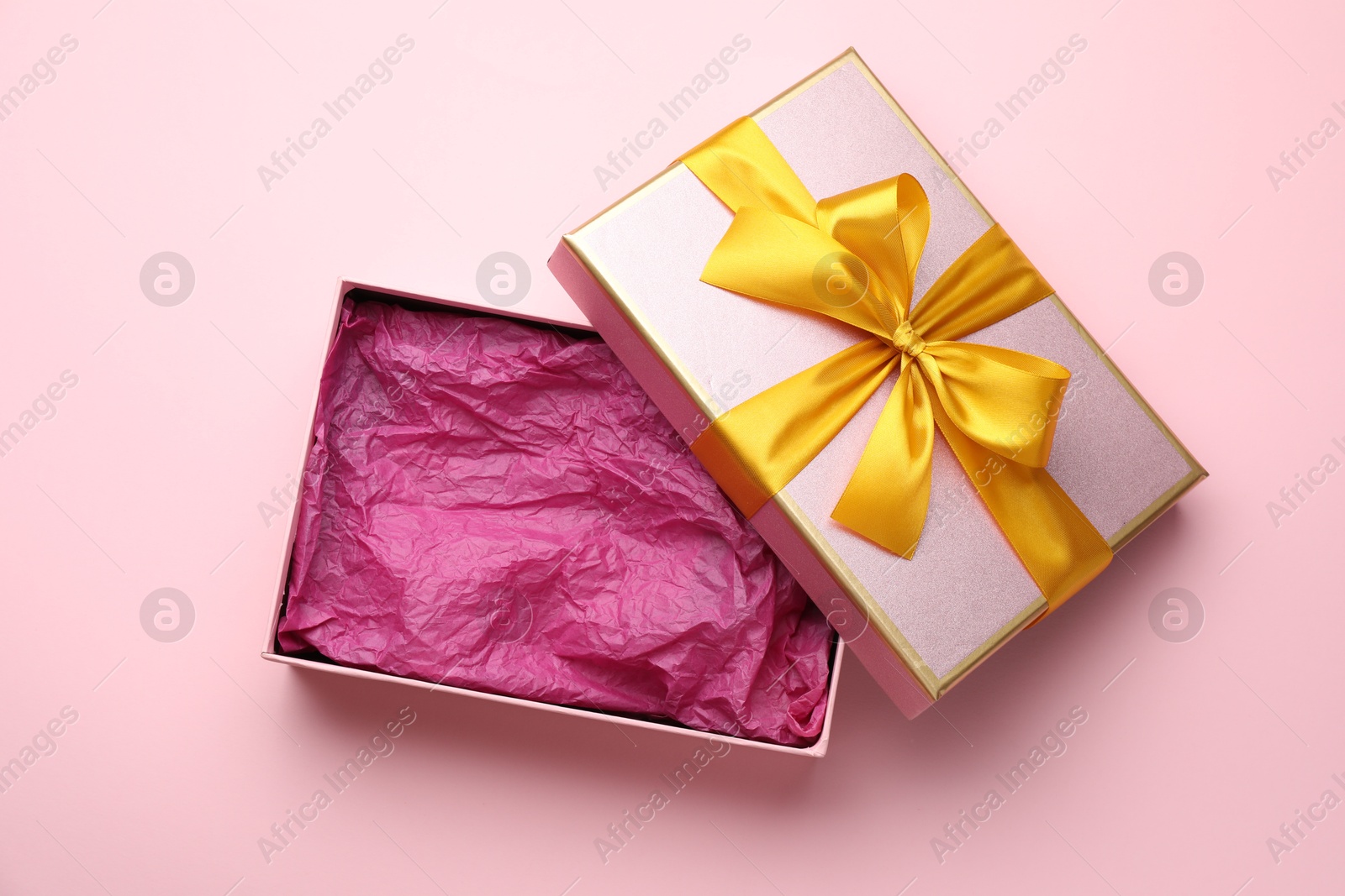 Photo of Open gift box with beautiful lid on pink background, top view