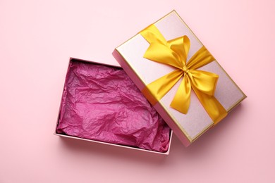 Photo of Open gift box with beautiful lid on pink background, top view