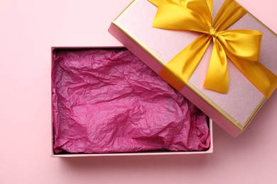 Photo of Open gift box with beautiful lid on pink background, top view