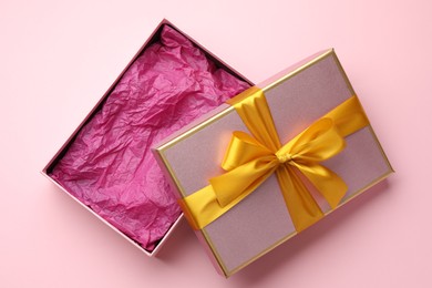 Photo of Open gift box with beautiful lid on pink background, top view