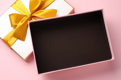 Photo of Open gift box with beautiful lid on pink background, top view