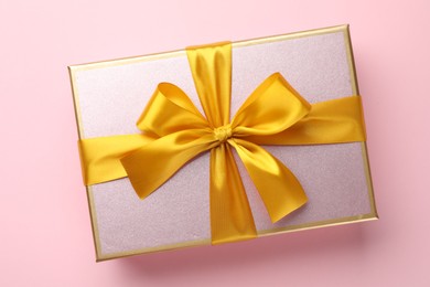 Photo of Beautiful gift box with bow on pink background, top view