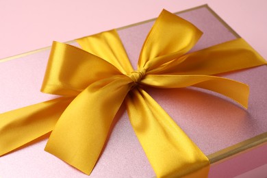 Photo of Beautiful gift box with bow on pink background, closeup