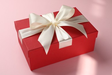 Photo of Beautiful gift box with bow on pink background