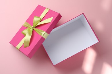 Photo of Open gift box with beautiful lid on pink background, top view