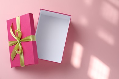 Photo of Open gift box with beautiful lid on pink background, top view. Space for text