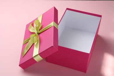Photo of Open gift box with beautiful lid on pink background