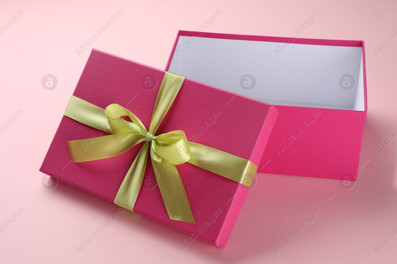 Photo of Open gift box with beautiful lid on pink background