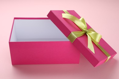 Photo of Open gift box with beautiful lid on pink background