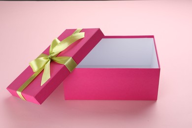 Photo of Open gift box with beautiful lid on pink background