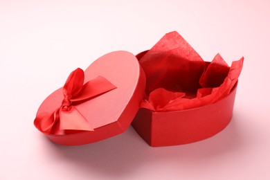 Photo of Heart-shaped gift box with beautiful lid on pink background