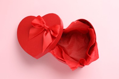 Photo of Heart-shaped gift box with beautiful lid on pink background, top view