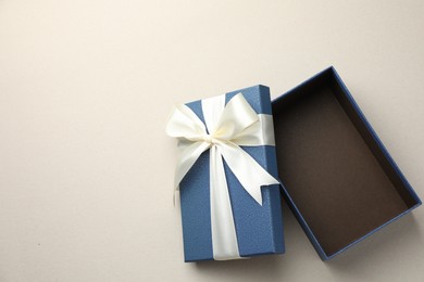 Photo of Open gift box with beautiful lid on light grey background, top view. Space for text