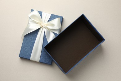 Photo of Open gift box with beautiful lid on light grey background, top view