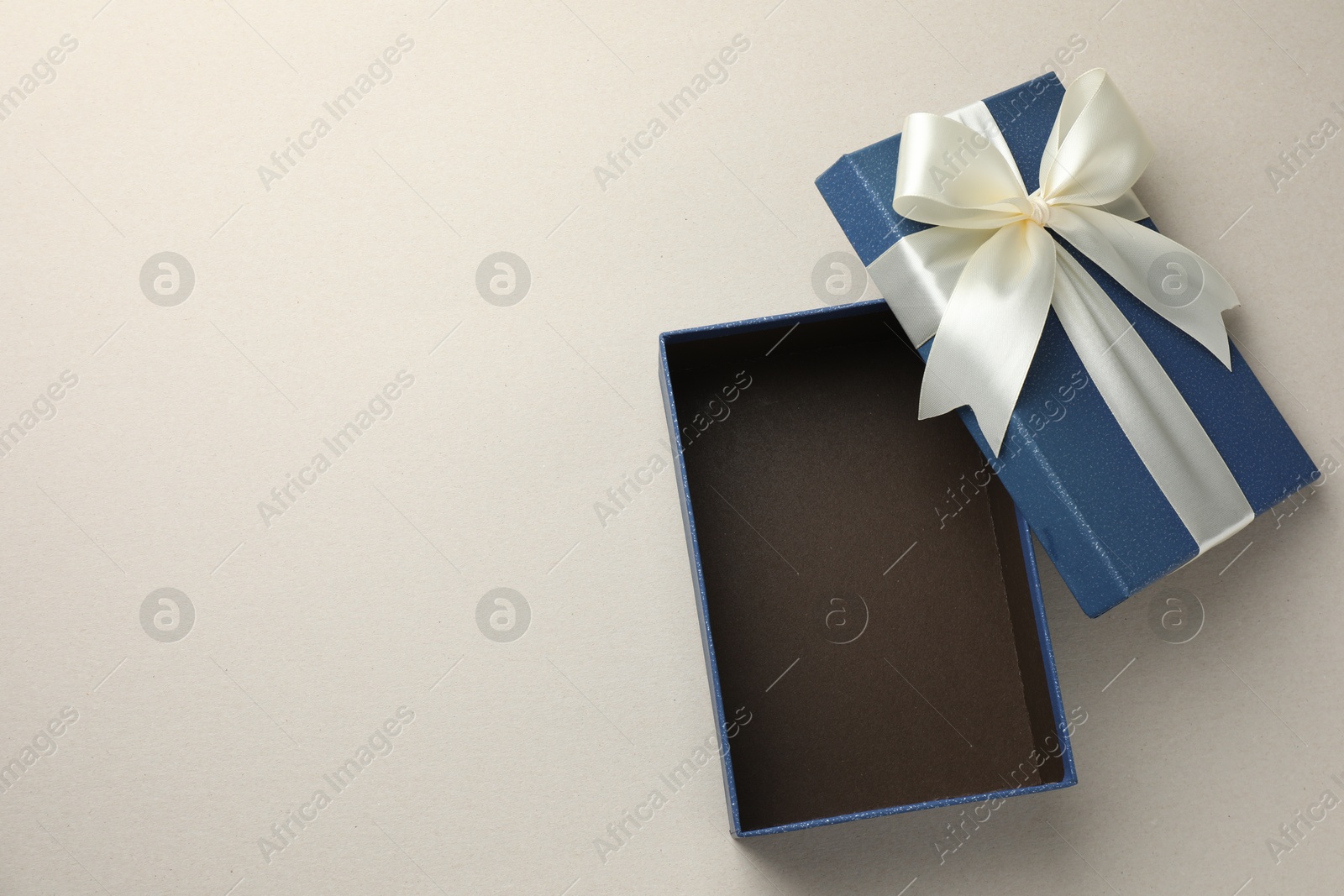 Photo of Open gift box with beautiful lid on light grey background, top view. Space for text