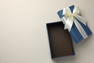 Photo of Open gift box with beautiful lid on light grey background, top view. Space for text