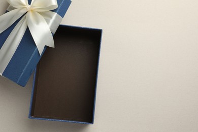 Photo of Open gift box with beautiful lid on light grey background, top view. Space for text