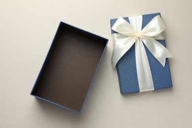 Photo of Open gift box with beautiful lid on light grey background, top view