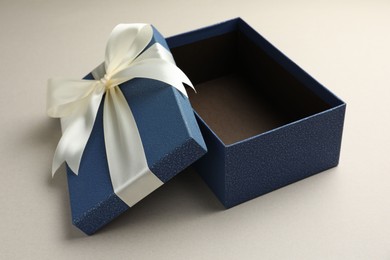 Photo of Open gift box with beautiful lid on light grey background