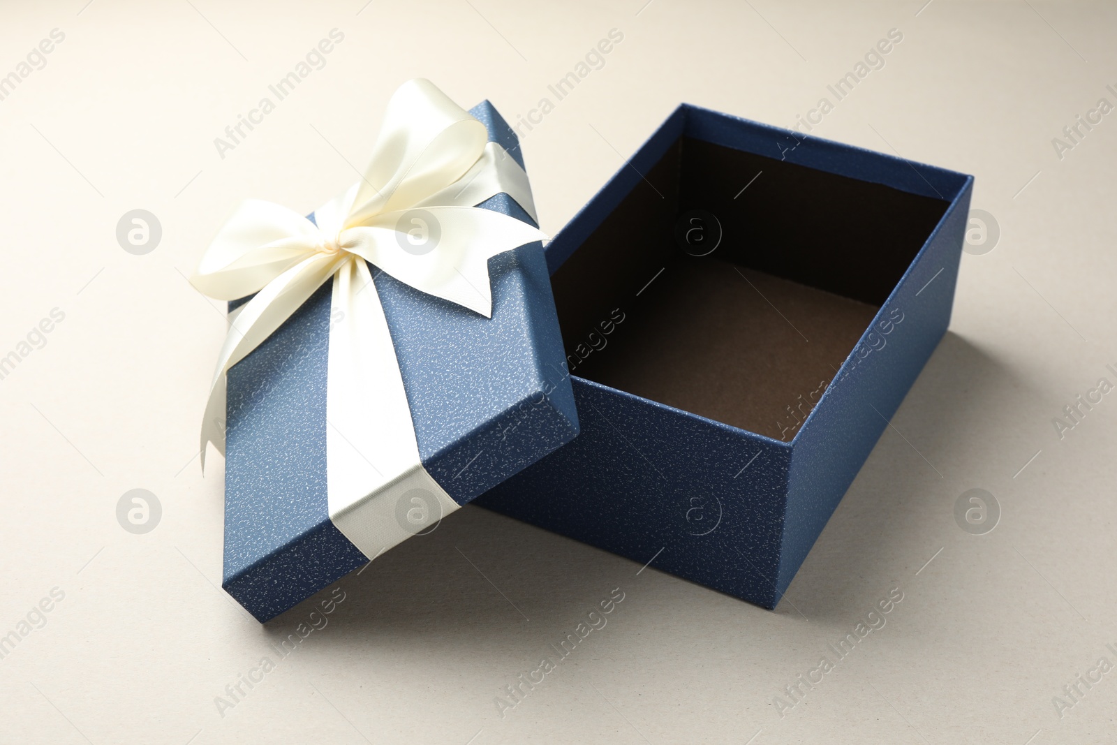 Photo of Open gift box with beautiful lid on light grey background