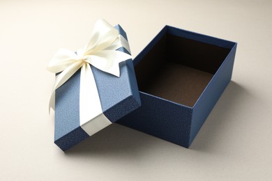 Photo of Open gift box with beautiful lid on light grey background