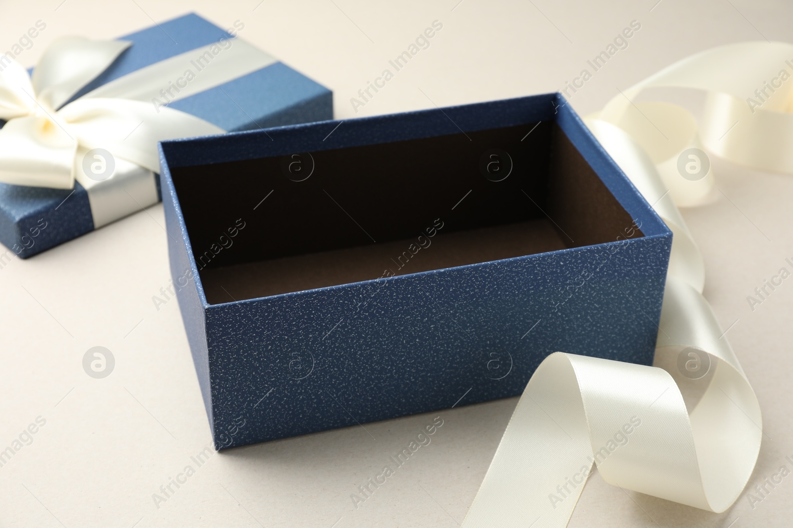 Photo of Open gift box with beautiful lid on light grey background