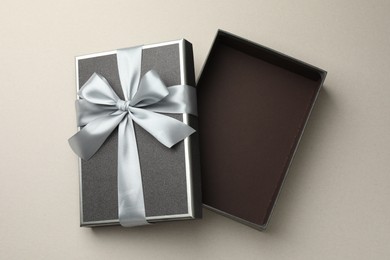Photo of Open gift box with beautiful lid on light grey background, top view