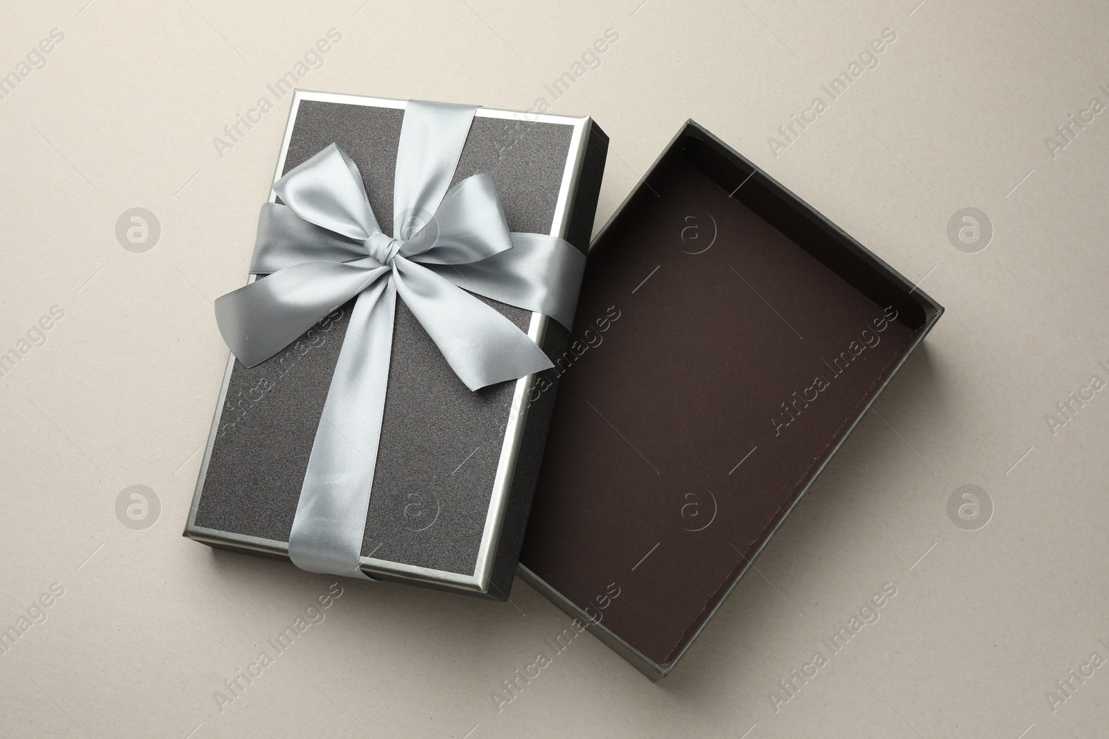 Photo of Open gift box with beautiful lid on light grey background, top view