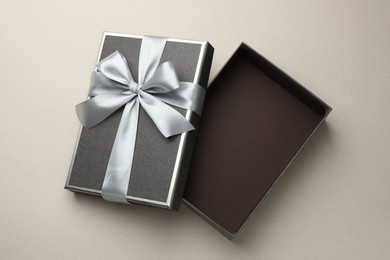 Photo of Open gift box with beautiful lid on light grey background, top view