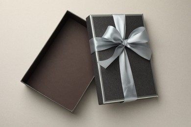 Photo of Open gift box with beautiful lid on light grey background, top view