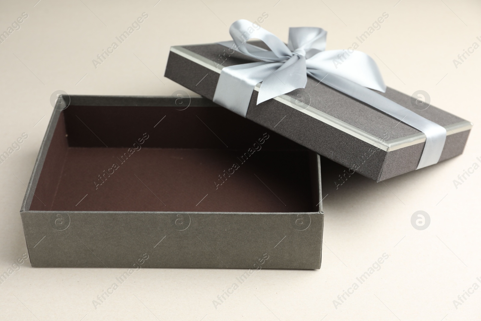 Photo of Open gift box with beautiful lid on light grey background