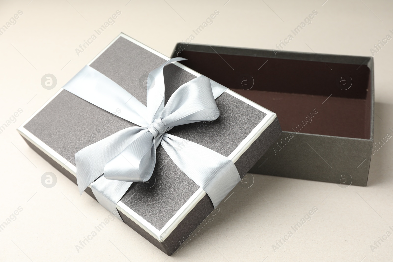 Photo of Open gift box with beautiful lid on light grey background