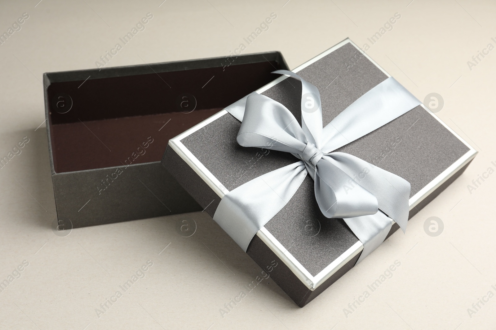 Photo of Open gift box with beautiful lid on light grey background