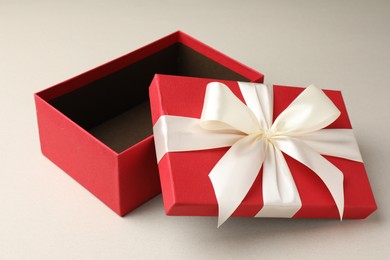 Photo of Open gift box with beautiful lid on light grey background