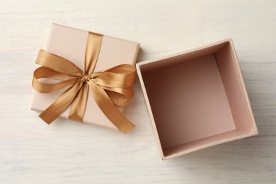 Photo of Open gift box with beautiful lid on white wooden table, top view