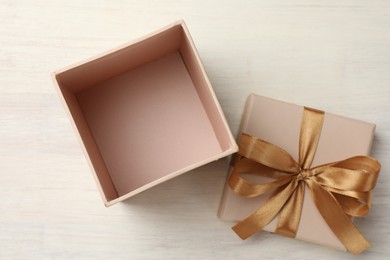 Photo of Open gift box with beautiful lid on white wooden table, top view