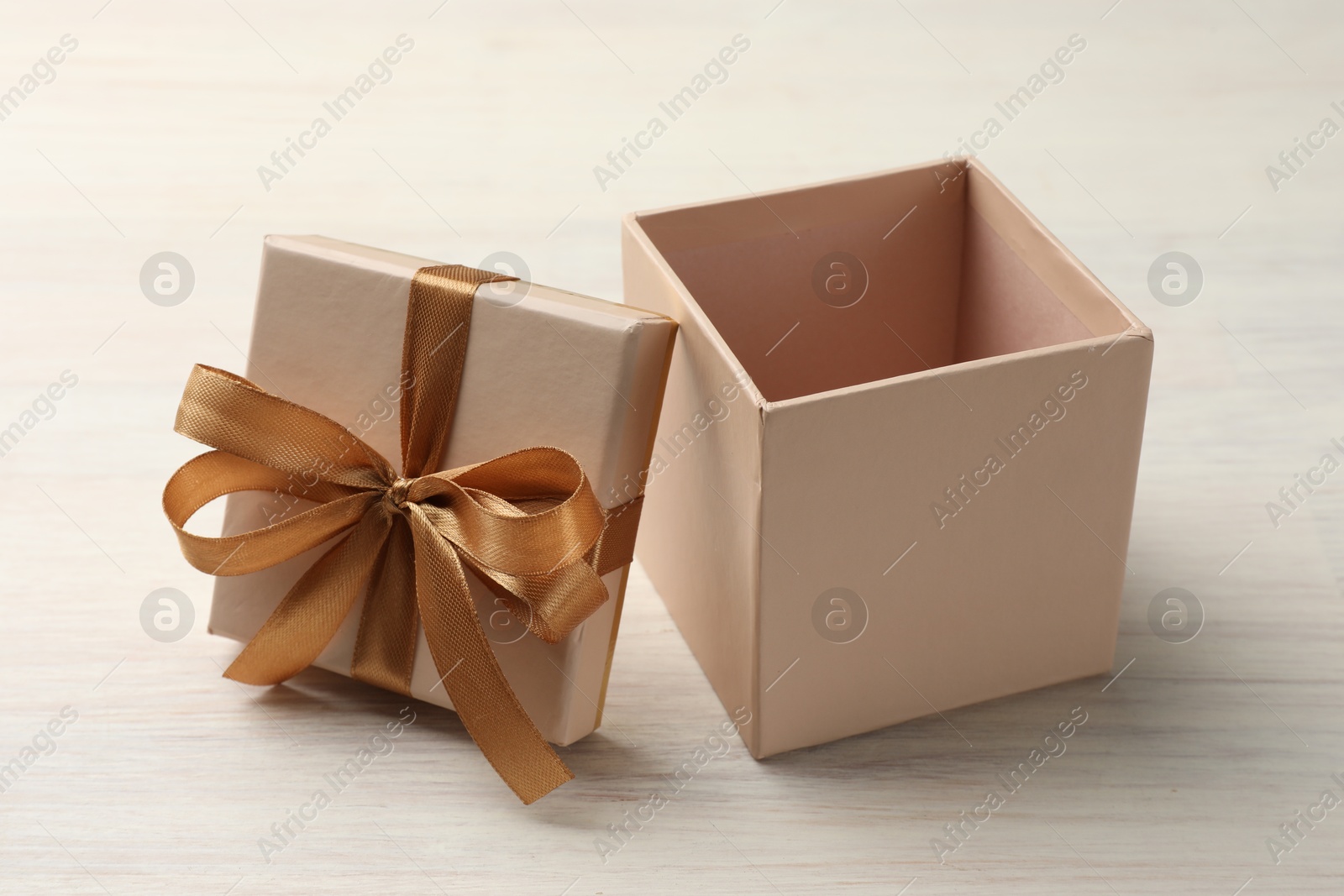 Photo of Open gift box with beautiful lid on white wooden table