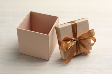 Photo of Open gift box with beautiful lid on white wooden table