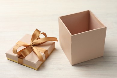 Photo of Open gift box with beautiful lid on white wooden table