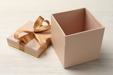 Photo of Open gift box with beautiful lid on white wooden table