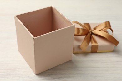 Photo of Open gift box with beautiful lid on white wooden table