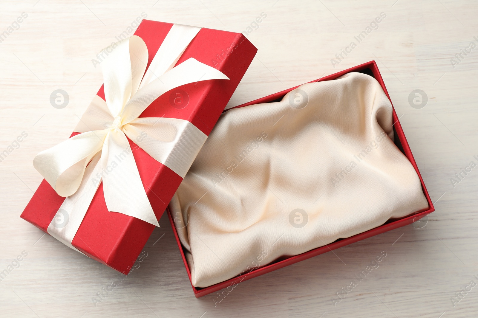 Photo of Open gift box with beautiful lid on white wooden table, top view