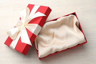 Photo of Open gift box with beautiful lid on white wooden table, top view