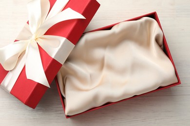 Photo of Open gift box with beautiful lid on white wooden table, top view