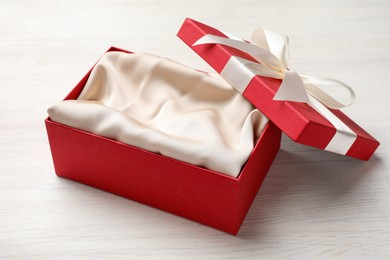 Photo of Open gift box with beautiful lid on white wooden table
